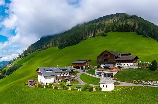 Der Voppichlhof umgeben von Wiesen und Wäldern.