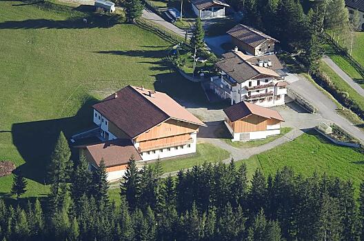 The Huterhof in summer: Here you can see the newly built farm building and the residential building with the playground behind it.