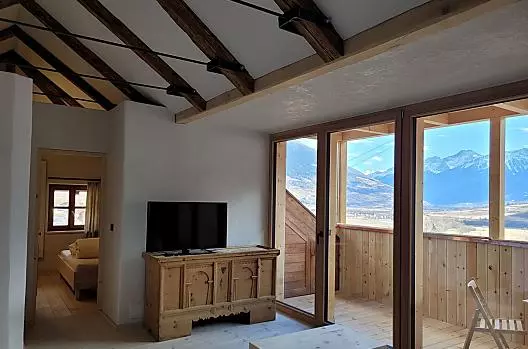 Wohnzimmer mit Blick auf Balkon und Panorama