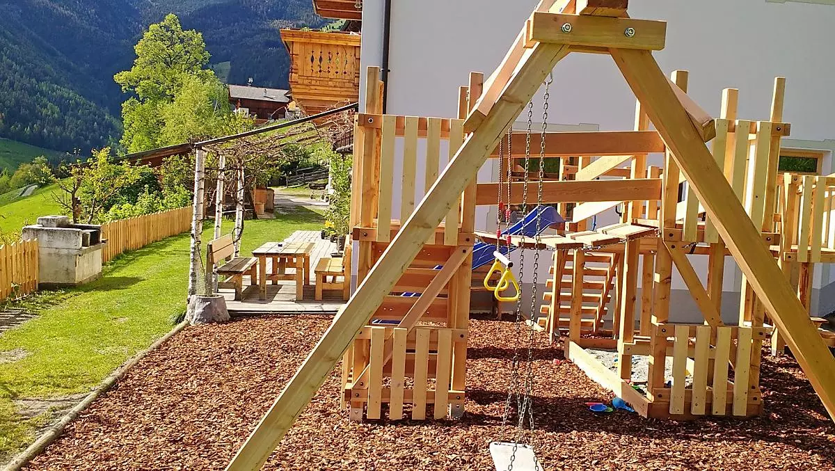 Der Spielplatz, im Hintergrund die Gartenlaube und der Grill.