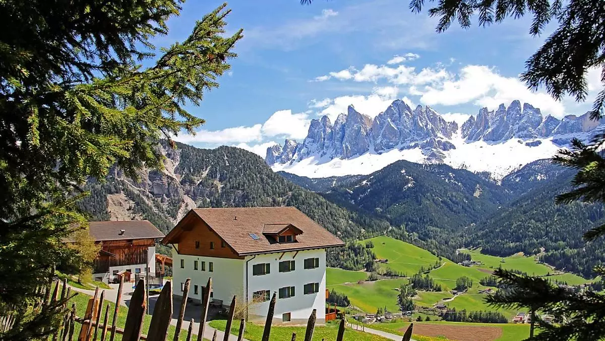 Farm view in spring with snow on the Geisler group