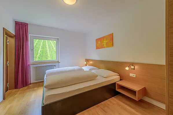 Doppelzimmer mit Weinbergblick und großem Bad mit begehbarer Dusche und dreiteiligem Schrank, Holzboden, Bettenlänge 210 cm.