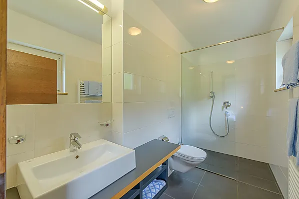 Helles, großes Badezimmer mit begehbarer Dusche/WC, Föhn, Handtücher, Badetücher, vom Schlafzimmer aus zugänglich.