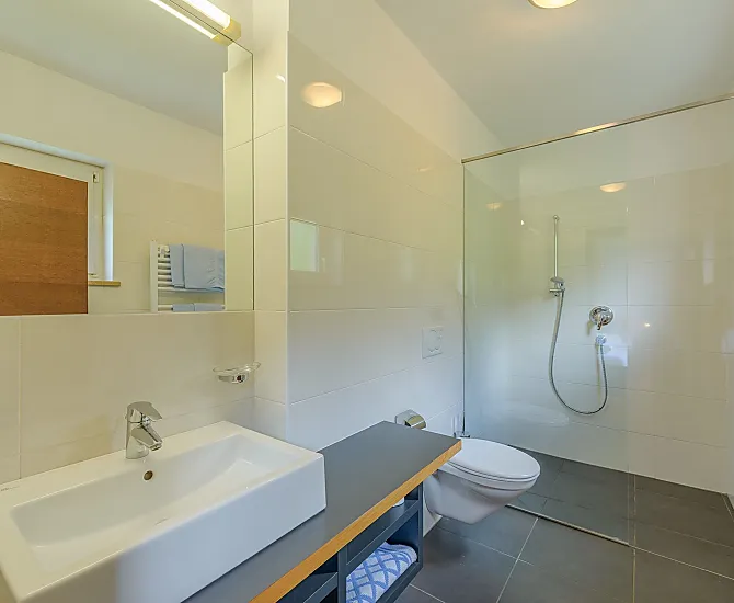 Helles, großes Badezimmer mit begehbarer Dusche/WC, Föhn, Handtücher, Badetücher, vom Schlafzimmer aus zugänglich.