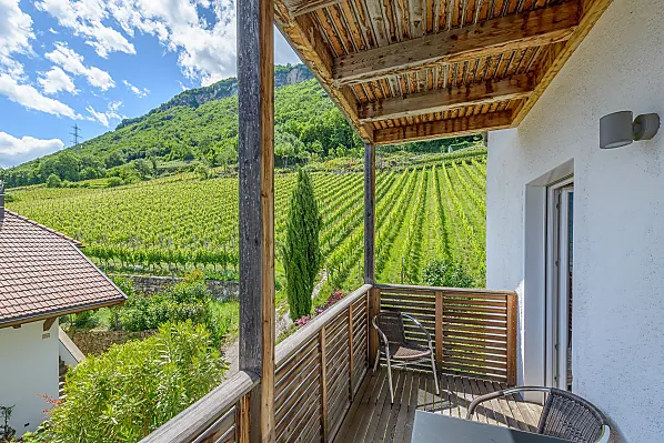 Südseitiger Balkon mit Weinbergblick und Esstisch und ein weiterer Balkon mit Talblick und Wäscheständer.