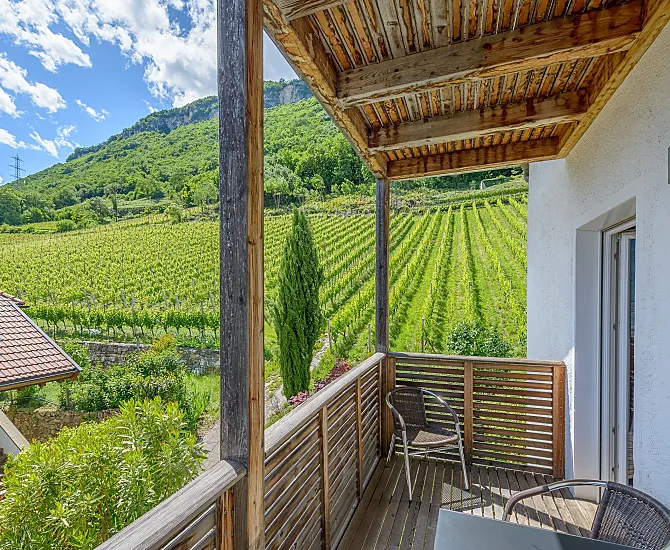 Südseitiger Balkon mit Weinbergblick und Esstisch und ein weiterer Balkon mit Talblick und Wäscheständer.