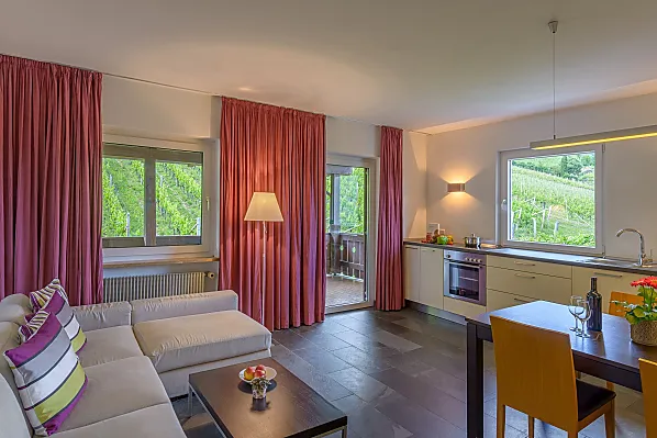 Wohnküche mit überdachter Terrasse, Weinbergblick, Ausblick nach Tramin und auf den Infinity-Pool mit Liegewiese