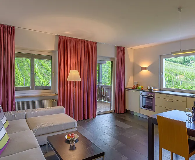 Wohnküche mit überdachter Terrasse, Weinbergblick, Ausblick nach Tramin und auf den Infinity-Pool mit Liegewiese