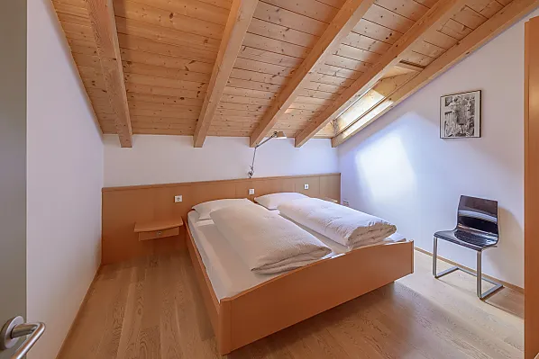 Ruhiges Schlafzimmer mit Doppelbett und dreiteiligem Schrank