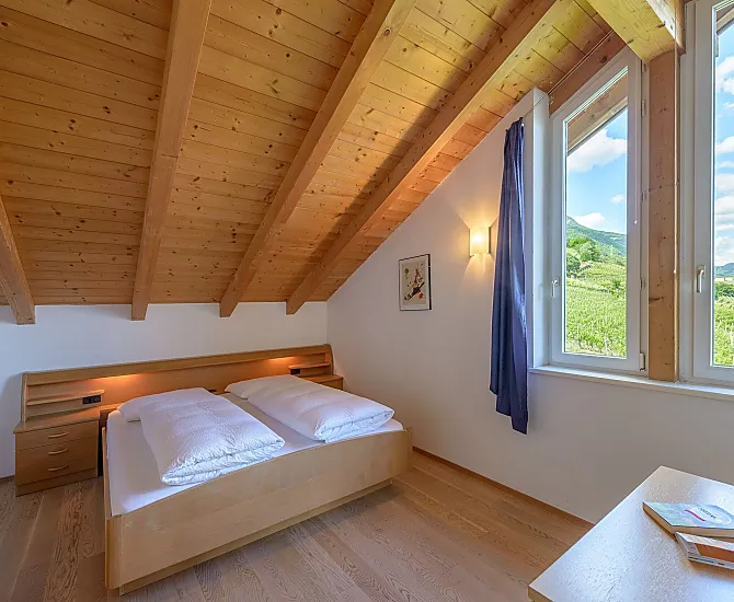 Schlafzimmer mit herrlichem Ausblick auf Tramin, den Poolbereich, in die Weinberge, in die Berge bis zur Sarner Scharte und aufs Weisshorn